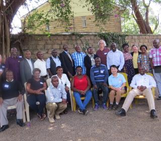 A large group of people gather for a photo in Kenya. 