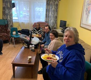 A group of adults sitting around a living room 