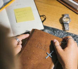 A person's hands holding a Bible.