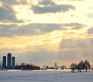 Sunbeams coming through the clouds over an Alberta farm.