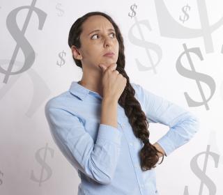 A woman surrounding by money symbols, pondering finances.