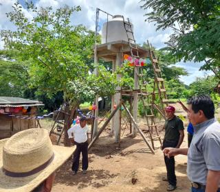 Locals assist with the installation of a solar powered well in their village