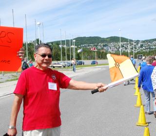 Indigenous elder Jim White holds a flag to start the Alvin Dixon Run at the 42nd General Council in Ottawa.