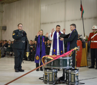 Military chaplains from several different denominations consecrate the guidon of the Saskatchewan Dragoons in a ceremony.