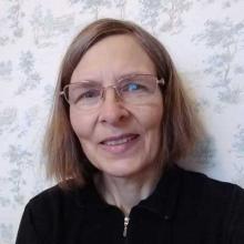 Dr. Katharina Manassis, a woman with auburn hair and glasses, smiling.