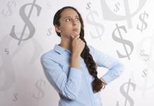 A woman surrounding by money symbols, pondering finances.