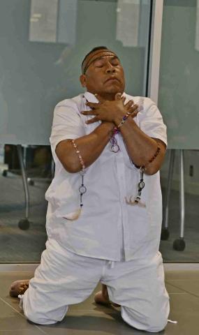 Juan Luis Mendoza de la Cruz performs in The Sunflower Man dance. A migrant farmworkers in real life, Luis is dress in traditional white of Mexican workers and knees with his arms crossed on this chest, as if praying.