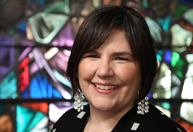 Carmen Lansdowne standing in front of stained glass