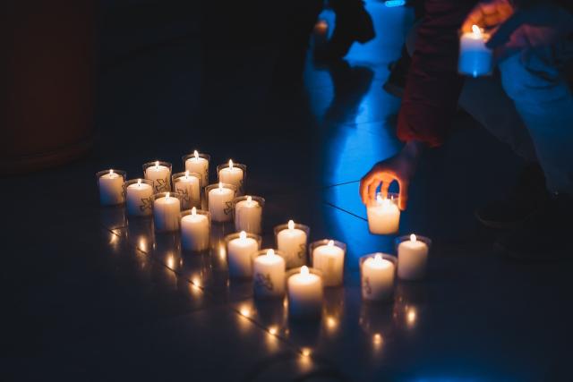 A row of lit votive candles in a church