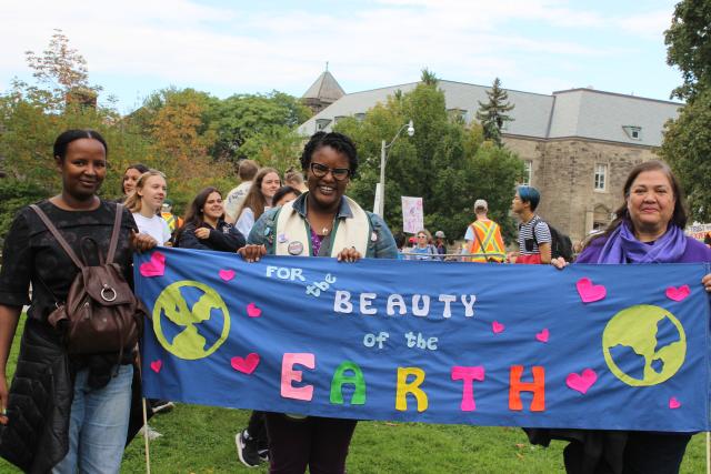 Alydia Smith holds a banner saying "for the beauty of the earth"