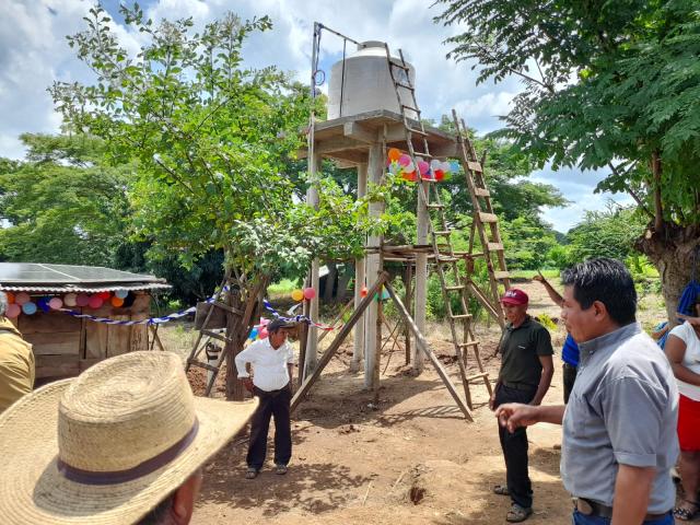 Locals assist with the installation of a solar powered well in their village