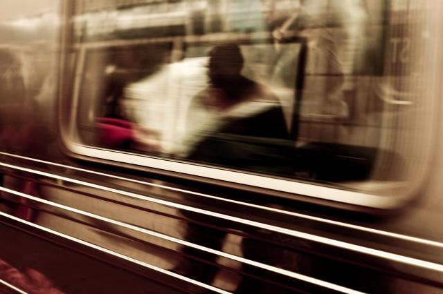 An image of a person's reflection in a subway window.