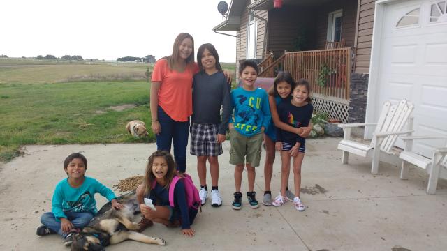 A group of First Nations  siblings gathered together in a yard.